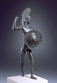 Statuette en bronze d'un soldat avec un casque à crête et un bouclier.