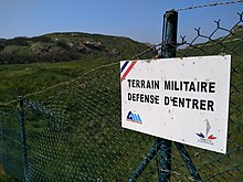 Clôture et panneau interdisant l'entrée sur la partie non déminée de l'île.