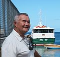 Captain Arthur Anslyn standing at the port in Nevis with MV Carib Queen behind him. He was Captain of that ferryboat for 19 years.