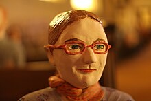 Photo d'une céramique en couleurs représentant une femme avec des lunettes.
