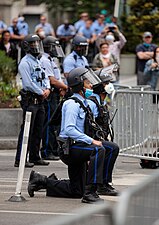 A policeman in Philadelphia takes the knee.