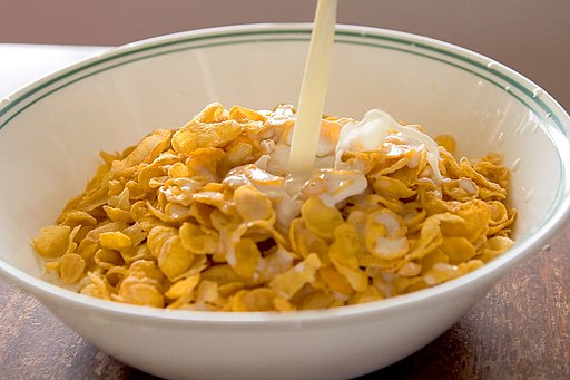 Cornflakes with milk pouring in