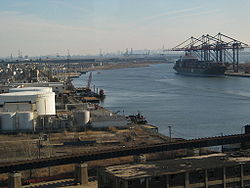 Staten Island Railroad (foreground) to Howland Hook travels the Arthur Kill Vertical Lift Bridge over the Arthur Kill and connects the Chemical Coast. EnteringElizabeth0614.JPG