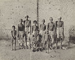 Group of men and children suffering from famine in India.jpg