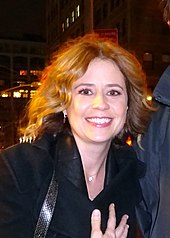 Photographie d'une jeune femme regardant la caméra en souriant.