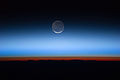Biletet viser månen i sentrum, med lag av Jordaatmosfæra frå Jorda ved botnen og overgangen inn i den oransje-farga troposfæren. Troposfæren sluttar brått ved tropopausen, som i biletet framstår som den skarpe grensa mellom oransje- og blå-farga atmosfære. Dei sølvfarga-blå nattlysande skyene strekker seg langt over jordas troposfære.