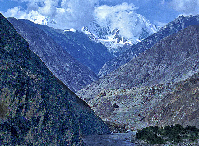 The Indus Gorge is formed as the Indus River bends around the Nanga Parbat massif, shown towering behind, defining the western anchor of the Himalayan