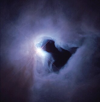 The reflection nebula NGC 1999 is brilliantly illuminated by V380 Orionis. The black patch of sky is a vast hole of empty space and not a dark nebula as previously thought. Ngc1999.jpg