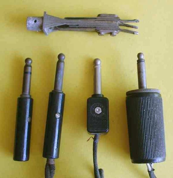 Old connectors. On the top is a TRS socket. Plugs are below. The leftmost is a TRS plug; the rest are TS plugs.