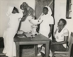 Tanzanian midwife weighing an infant and giving advice to the mother The National Archives UK - CO 1069-157-11 cropped.jpg