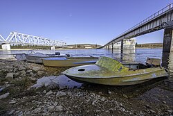 Vissersboten op de oever van de Amga tussen de spoorbrug (links) en de wegbrug (rechts)