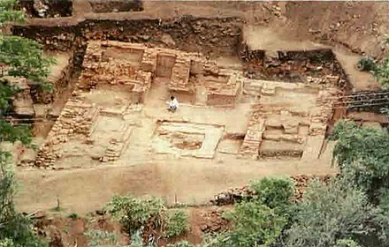 The vihara brick monastery facing the caves at Ajanta. The cells were built around a stupa set on a central platform.[107]