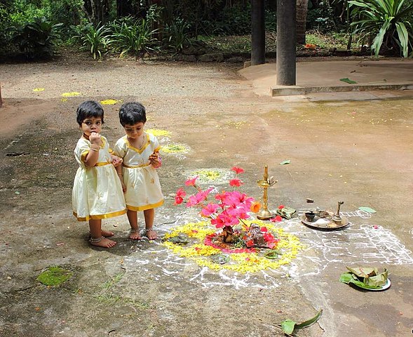 ഓണക്കോടിയുടുത്തു പൂവട കഴിക്കുന്ന കുട്ടികള്‍