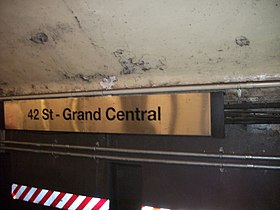 Metal sign on tunnel wall with 42 St–Grand Central name