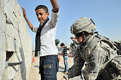 Image 33U.S. Army soldier searches an Iraqi boy, March 2011 (from History of Iraq)