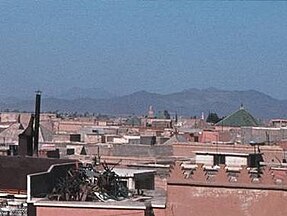Atlas Mountains can be seen over the roofs of Marrakech