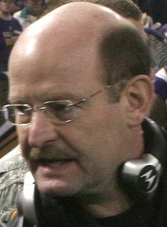 Foto na cabeça de um homem branco careca (Brad Childress) com fone de ouvido