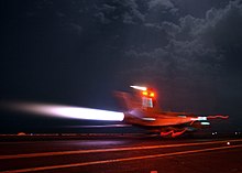 An aircraft lights its afterburners to maintain full power during an arrested landing aboard an aircraft carrier. If the arrested landing fails, the aircraft can safely take off again. FA-18-Afterburners.jpg