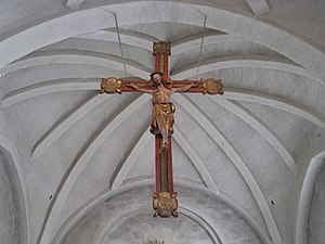 Triumfkrucifixet hänger i kyrkans triumfbåge.