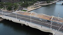 中の橋 俯瞰。下流側歩道にひまわりのモザイクとオブジェがある。