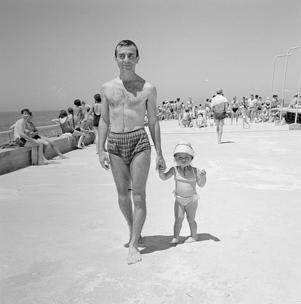 File:Man en kind lopen in badkleding over een boulevard langs het strand, Bestanddeelnr 255-1959.jpg