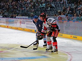 Helbling (oikealla) EV Zugin paidassa European Trophy -ottelussa saksalaista Adler Mannheimia vastaan lokakuussa 2012. Vasemmalla Adlerin NHL:n työsulkuvahvistus Marcel Goc.