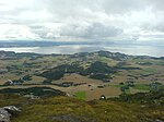 Foto von einer Anhöhe auf eine an der Küste gelegenen Ortschaft herab