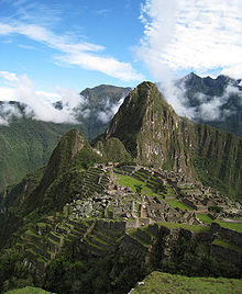 Een luchtfoto van een Inca-stad midden in een landschap van hoge bergen.