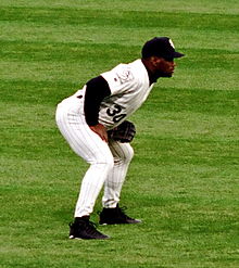 Joueur de baseball dans un maillot noir et blanc, tenant sa casquette