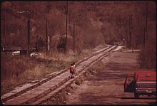 Youngsters walk on ties of railroad track that passes through Fireco (1974) YOUNGSTERS WALK ON TIES OF THE RAILROAD TRACKS THAT PASS THROUGH FIRECO, WEST VIRGINIA, NEAR BECKLEY. IN THE OLD... - NARA - 556490.jpg