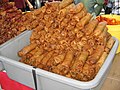 popiah goreng renyah dan panas, yang terkenal di Malaysia. Di bagian kirinya disediakan saus cabai.