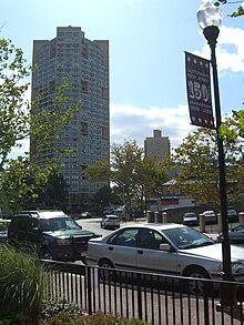 A 2009 sign on Boulevard East advertising the town's 150th anniversary. In the background is one of the three towers of the Galaxy apartments.