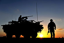 A Jackal armoured vehicle of the Household Cavalry Regiment in Helmand Province, Afghanistan, in 2011. A Jackal Vehicle and Soldier Stand Guard at a Vehicle Checkpoint in Afghanistan MOD 45153290.jpg