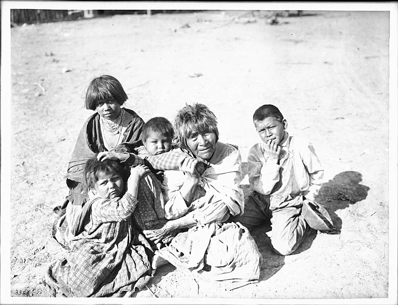 File:Apache Indian grandmother carrying her grandchild on her back and three others sitting nearby, Palomas Indian Reservation, 1903 (CHS-3586A).jpg