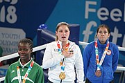 Deutsch: Boxen bei den Olympischen Jugendspielen 2018 Tag 12, 18. Oktober 2018 - Medaillenzeremonie im Fliegengewicht der Mädchen - Gold: Martina La Piana (Italien), Silber: Adijat Gbadamosi (Nigeria), Bronze: Heaven Destiny Garcia (USA); Medaillenübergabe durch Habu Gumel (IOC, Nigeria), Geschenkübergabe durch Dr. Joseph O. Ayeni (Nigeria, AIBA). English: Boxing at the 2018 Summer Youth Olympics on 18 October 2018 – Girl's flyweight Medal Ceremony - Gold: Martina La Piana (Italy), Silver: Adijat Gbadamosi (Nigeria), Bronze: Heaven Destiny Garcia (USA); Medal handover by Habu Gumel (IOC, Nigeria), Gift presented by Dr. Joseph O. Ayeni (Nigeria, AIBA). Español: Boxeo en los Juegos Olímpicos Juveniles de Verano de 2018 en 18 de octubre de 2018 - Ceremonia de la Medalla de peso mosca para niñas - Oro: Martina La Piana (Italia), Plata: Adijat Gbadamosi (Nigeria), Bronce: Heaven Destiny Garcia (Estados Unidos); Entrega de medallas por Habu Gumel (COI, Nigeria), Regalo presentado por Joseph O. Ayeni (Nigeria, AIBA).