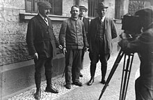 German serial killer Fritz Haarmann with police detectives, November 1924 Bundesarchiv Bild 102-00824, Hannover, Prozess gegen Friedrich Haarmann.jpg
