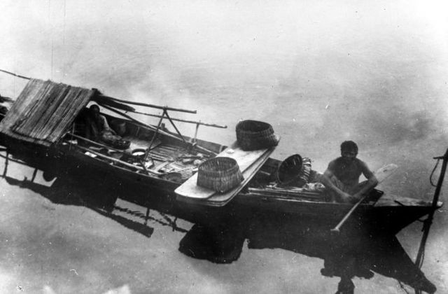 An Orang Laut family living in a boat, circa 1914–1921.