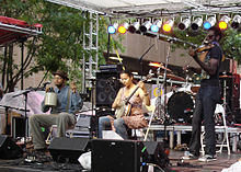 The Carolina Chocolate Drops performing at the City Stages Festival, in Birmingham, Alabama, United States in 2008. From left to right: Dom Flemons, jug; Rhiannon Giddens, 5-string banjo; Justin Robinson, fiddle Carolinachocolatedrops.jpg