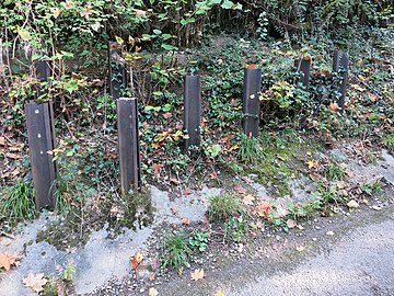 Barrage antichar complétant la barricade routière démentelée d'une route locale sans issue.