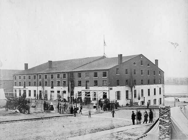 a three-story brick warehouse with a gabled roof