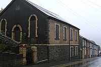 High Street, Cymmer; the A4233 runs past the Welsh Baptist Chapel (Capel Bedyddwyr Cymraeg Pisgah), built in 1894. Still in use in 1998, the chapel is now closed and boarded up