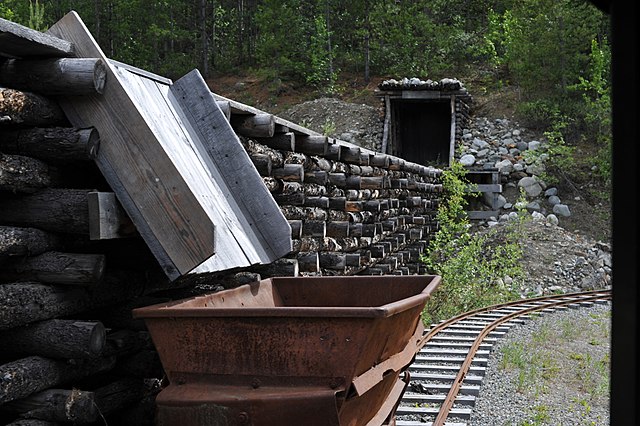 A conveyor belt and cart outside of a mine tunnel in the Yukon. The economy of the territory has historically been centred around mining.