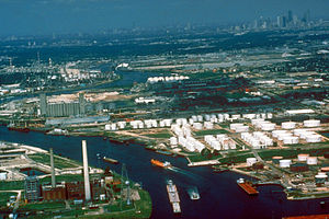 A color photograph of a waterway, with a cityscape in the upper right corner