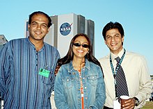 Ashutosh Gowariker, his wife Sunita and actor Shahrukh Khan pose for a photo with the Vehicle Assembly Building, Kennedy Space Center in the background during filming for the movie Swades