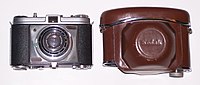 The first rigid model of Retinette (Model 022) introduced in 1954. Lens is Schneider Kreuznach Reomar and the shutter is Compur-Rapid. Leather carrying case was included with the camera. A 29.5 mm skylight filter is attached to the lens. The lever on the left of the lens at 9 o' clock is the self-timer actuator. Construction of the body is all-metal, including the film advance lever at the bottom. The lens mounting plate is rectangular Kodak Retinette and case.JPG