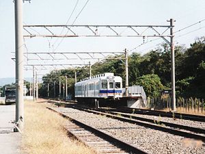 停靠中的2200系電動列車（日语：南海22000系電車）。後方是和歌山市方向。 月台右邊小屋可隱約看見路線時間表。 （2001年10月）
