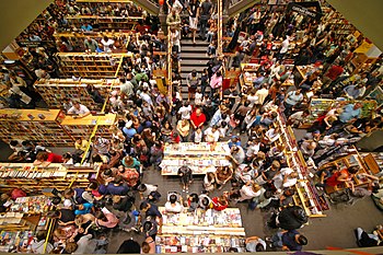 There are many people in close proximity in a bookstore buying 