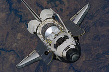 Discovery nähert sich während STS-121 der Internationalen Raumstation.  Die Nutzlast im Frachtraum des Shuttles würde später in der Mission an der ISS befestigt.  Das einzigartige „Tränen“-Merkmal des Raumschiffs, bestehend aus mehreren schwarzen Kacheln in der Nähe des Cockpits, ist deutlich sichtbar.