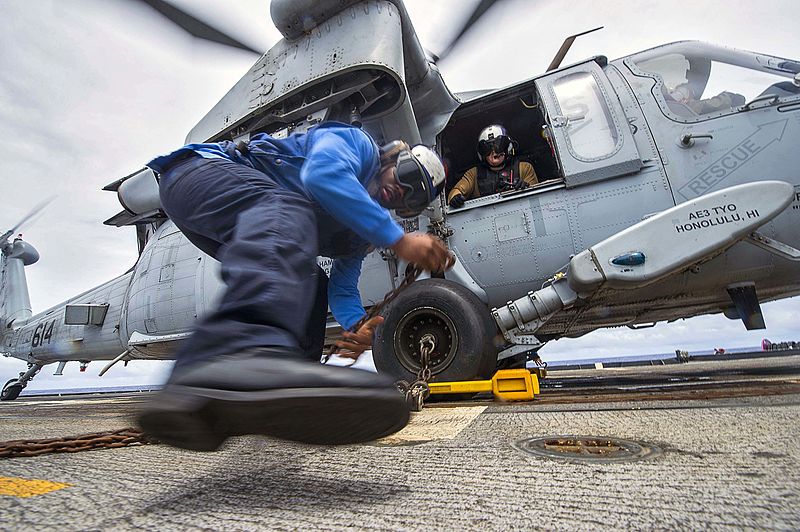 800px-Sailor_secures_an_MH-60s_Sea_Hawk_helicopter_with_chocks_and_chains_on_the_flight_deck_of_the_USS_Chancellorsville._%2829941244775%29.jpg