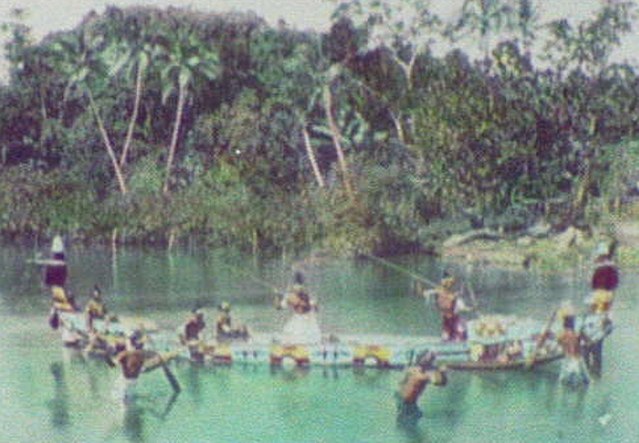 Solomon Island warriors, armed with spears, on board an ornamented war canoe (1895)